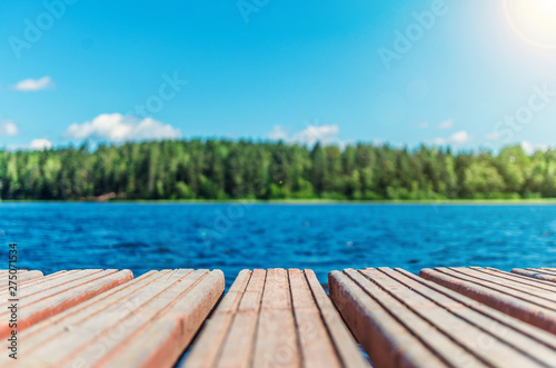 Fotomural Wooden timber of a rural mooring on a lake in the middle of the forest