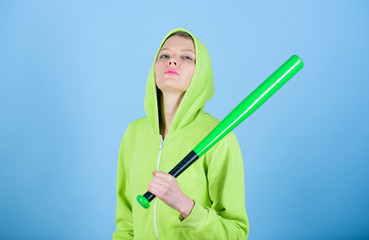 Girl hooded jacket hold baseball bat blue background. Woman in baseball sport. Baseball female player concept. She is dangerous. Girl troublemaker. Woman play baseball game or going to beat someone