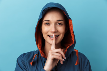 Wall Mural - Portrait of a cheerful young girl wearing raincoat standing