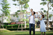 © xreflex - Happy Asian family. Father gave his daughter a piggyback at a park at natural sunlight background and house. Family vacation concept with copy space