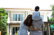 Happy Asian family. Father, mother and daughter near new home. Real estate background with copy space