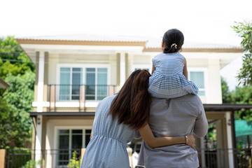 happy asian family. father, mother and daughter near new home. real estate background with copy spac