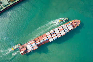 Aerial view and top view. Container ship in pier with crane bridge carries out export  and import business in the open sea. Logistics and transportation