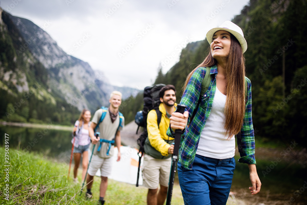 Group of young friends hiking in countryside. Multiracial happy people travelling in nature - obrazy, fototapety, plakaty 