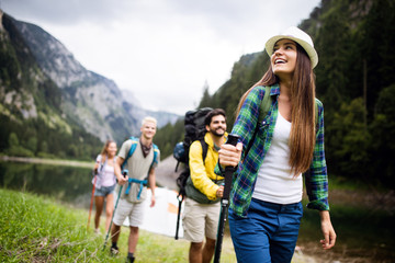 Wall Mural - group of young friends hiking in countryside. multiracial happy people travelling in nature