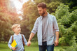 © Iryna - Relations father's feelings, tenderness concept. Beard handsome dad hugging his son outdoors in green park on background. Man saying goodbye to his little child before back to school.