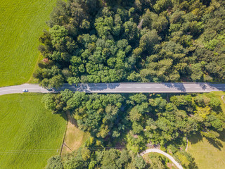 Aerial view of road bridge through dense green forest in Switzerland.