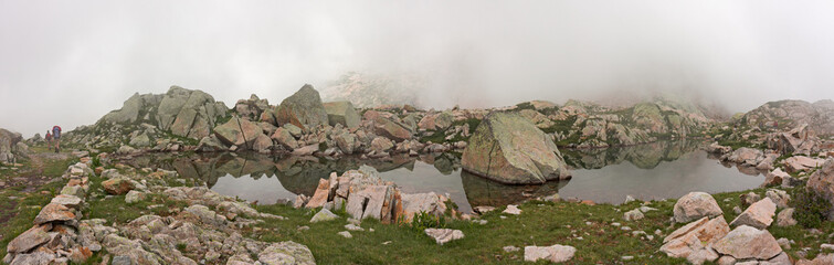 Wall Mural - some hikers walk along an old mule track near lake claus, in italy.