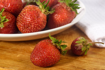 Ripe berries of garden strawberry close-up on a plate and on a Board