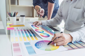 Poster - Two colleagues creative graphic designer working on color selection and drawing on graphics tablet at workplace