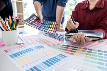 Poster - Two colleagues creative graphic designer working on color selection and drawing on graphics tablet at workplace
