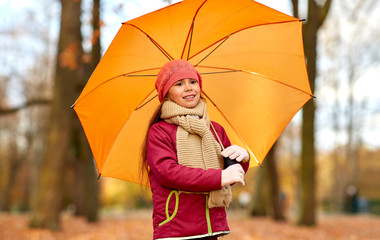 Sticker - childhood, season and weather concept - happy little girl with umbrella at autumn park