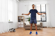 Fitness, Sport, Exercising And Healthy Lifestyle Concept - Indian Man Skipping With Jump Rope At Home