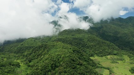 Wall Mural - Aerial drone view of clouds moving across the slopes of Mount Hibok-Hibok volcano with lush green farmland below (Camiguin, Philippines)