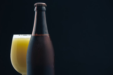 Poster - Close up Glass of beerand brown Bottle on a dark background behaid.