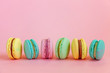 Sweet almond colorful unicorn pink blue yellow green macaron or macaroon dessert cake isolated on trendy pink pastel background. French sweet cookie. Minimal food bakery concept. Copy space