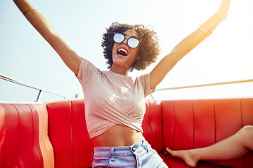 Wall Mural - Carefree young woman having fun on a boat during vacation