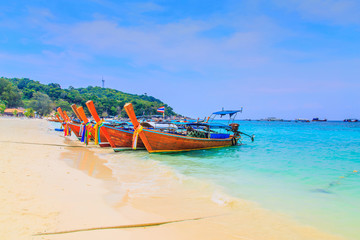 Long tailed boat at  kho lipe satun Thailand/Fishing boat on the sea and blue sky background at  kho lipe satun Thailand/Tropical beach kho lipe satun Thailand wooden long tailed boat on the sea/ 