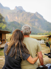 Couple as seen from behind looking out at the view of a mountain in Thailand. 