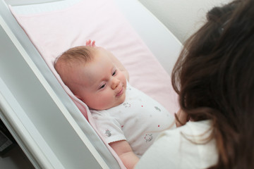 3 Month Old Cute Baby Girl, Infant ,lying on the white chanting table, laughs, looking on her Mother, New family concept, The most Beautiful Baby Princesse, Happy Baby Girl