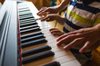 © zhukovvvlad - Children's and women's hands on the piano keys.