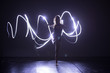 © qunica.com - Modern Dance performer dancing with a neon blue light while making gracious moves and spectacular body art expressions.