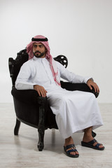 Wall Mural - Portrait of an arab man sitting down on a chair.