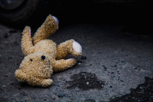 Concept: Lost Childhood, Loneliness, Pain And Depression. Teddy Bear Lying Down Outdoors.