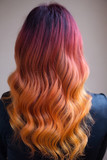 Woman with bright color dyed long curly hair