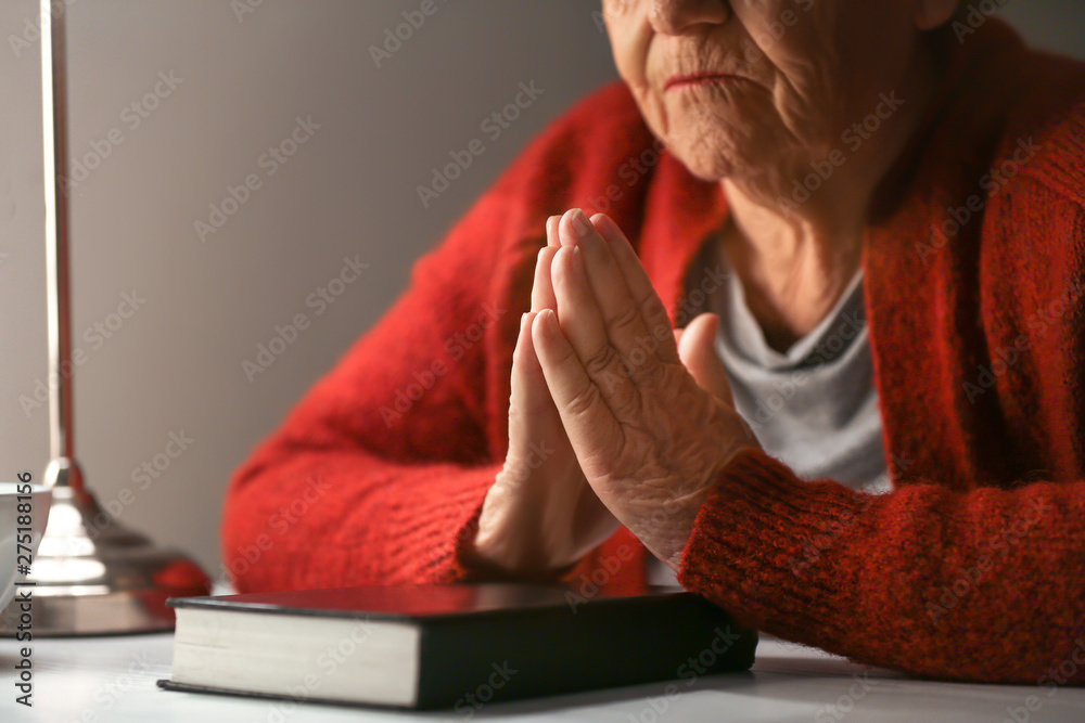 Senior woman praying to God at night