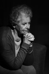 Wall Mural - Black and white portrait of praying senior woman