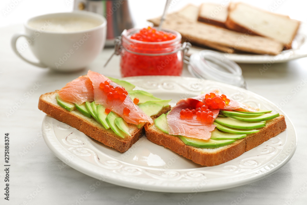 Plate with tasty avocado toasts on table