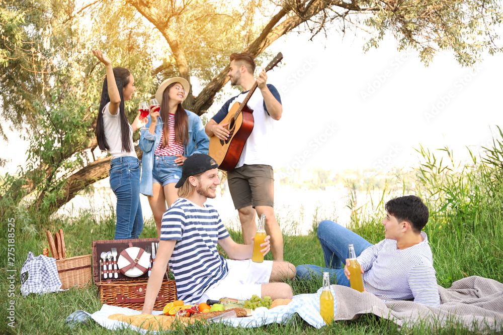 Happy friends on picnic in park