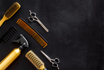 Poster - Combs and hairdresser tools in beauty salon work desk on black background top view mockup