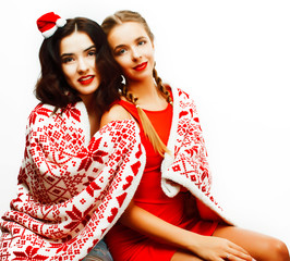 young pretty happy smiling blond and brunette woman girlfriends on christmas in santas red hat and holiday decorated plaid, lifestyle people concept close up