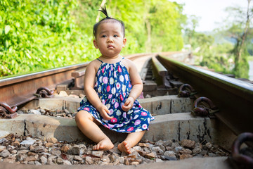 Baby girl sitting on railway