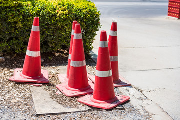 Red traffic cone on road in garden. Orange funnel use for beware car on the road in park.