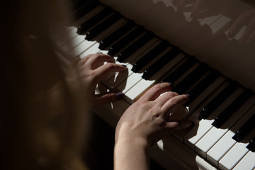 Woman hands playing a piano, musical instrument