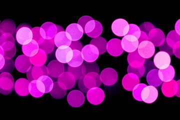 Unfocused abstract purple bokeh on black background. defocused and blurred many round light