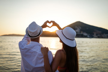 Wall Mural - Happy couple in love walking on beach on honeymoon vacation