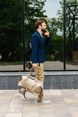 Wall Mural - Attractive young bearded man wearing jacket walking