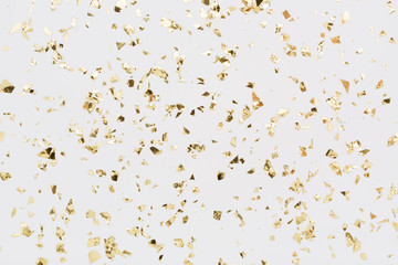 golden confetti on white background. festive, party or holiday glitter backdrop. flat-lay, top view.