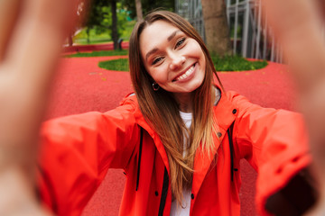 Poster - Chherful attractive young girl wearing raincoat