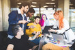 © xartproduction - Group of multi ethnic executives discussing during a meeting. Business man and woman sitting around table at office and smiling. A team of young creative designers