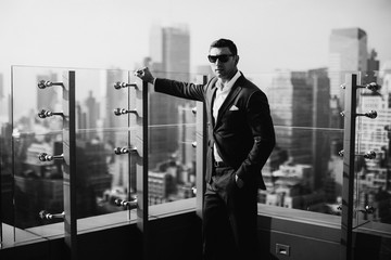 Wall Mural - A serious business man is photographed against the backdrop of modern buildings