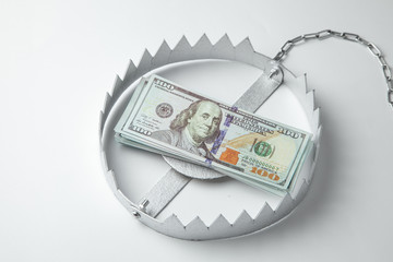 Trap with a stack of money. Dangerous risk for investment or deception in business. Gray background.