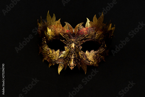 Venetian mask in gold and red with metallic pieces in the form of leaves. original and unique design, handmade crafts
