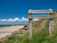 Weathered Wooden Sign Showing A Closure Of The Pembrokeshire Coast Path Near Newgale Beach, Taken In Summer Aganst A Blue Sky
