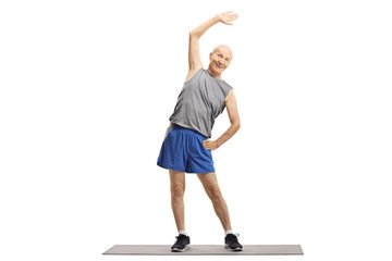 Canvas Print - Elderly man doing a stretching exercise on a mat