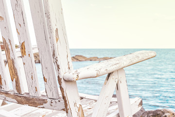 Weathered sunchair with a view over the ocean, bright colors at the rocky seashore of the Baltic sea